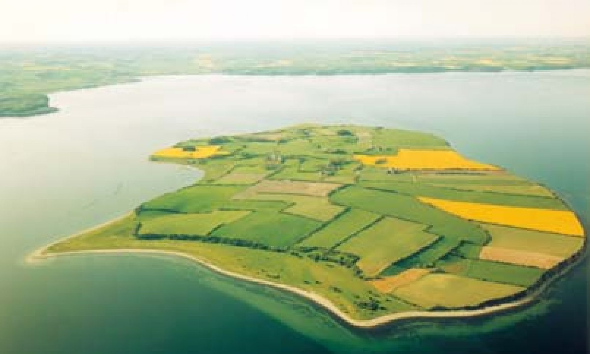 Luftfoto af Barsø med marker, kyst og hav