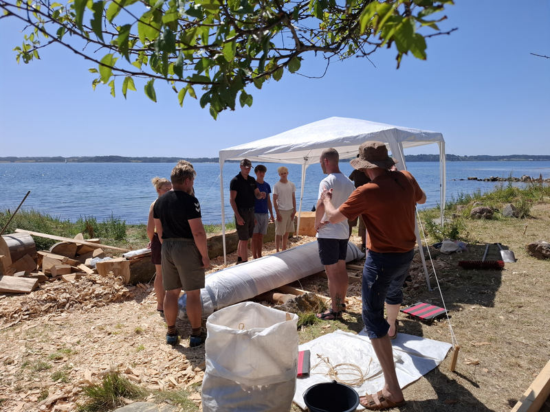 Folk arbejder med træ ved vandet på Barsø