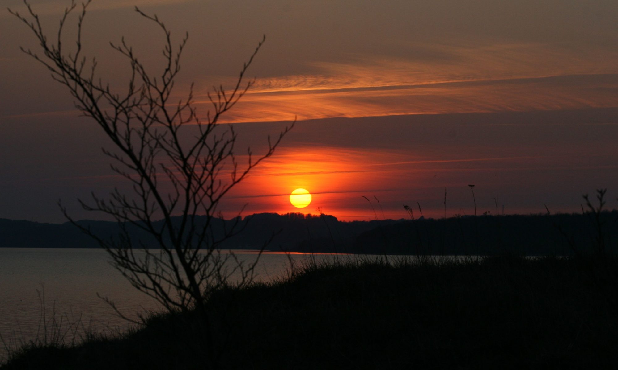 Solnedgang over vandet ved Barsø